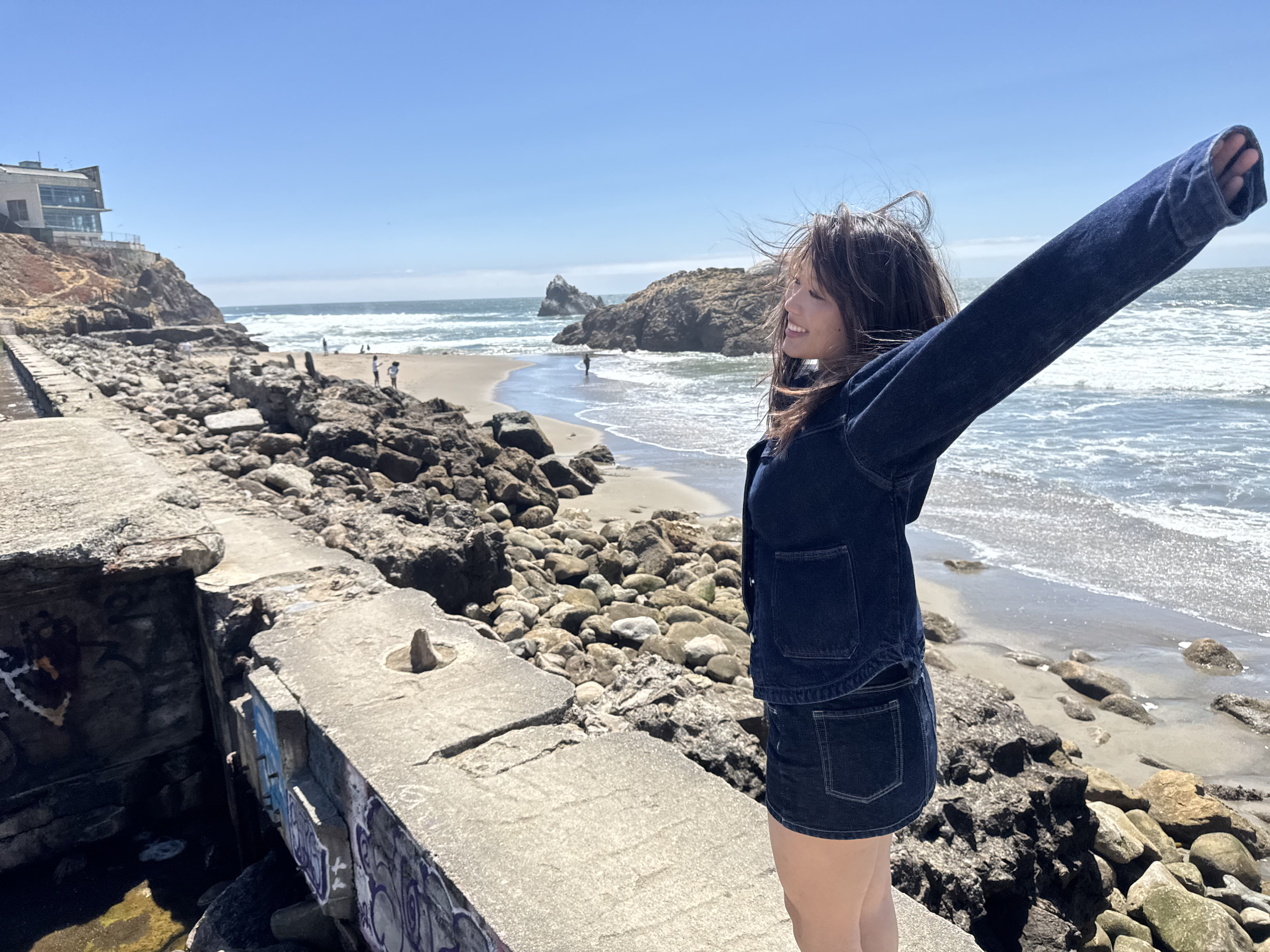 Mina standing on a rocky coast